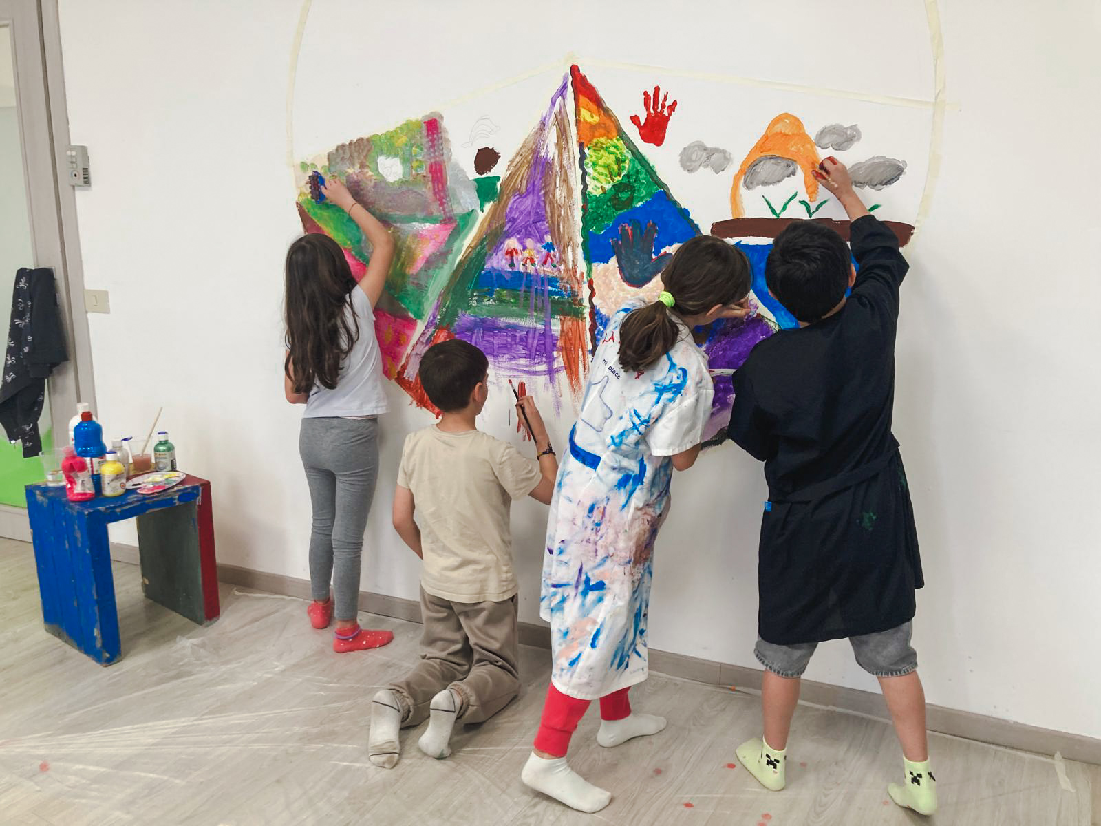 Bambini impegnati in un’opera pittorica condivisa